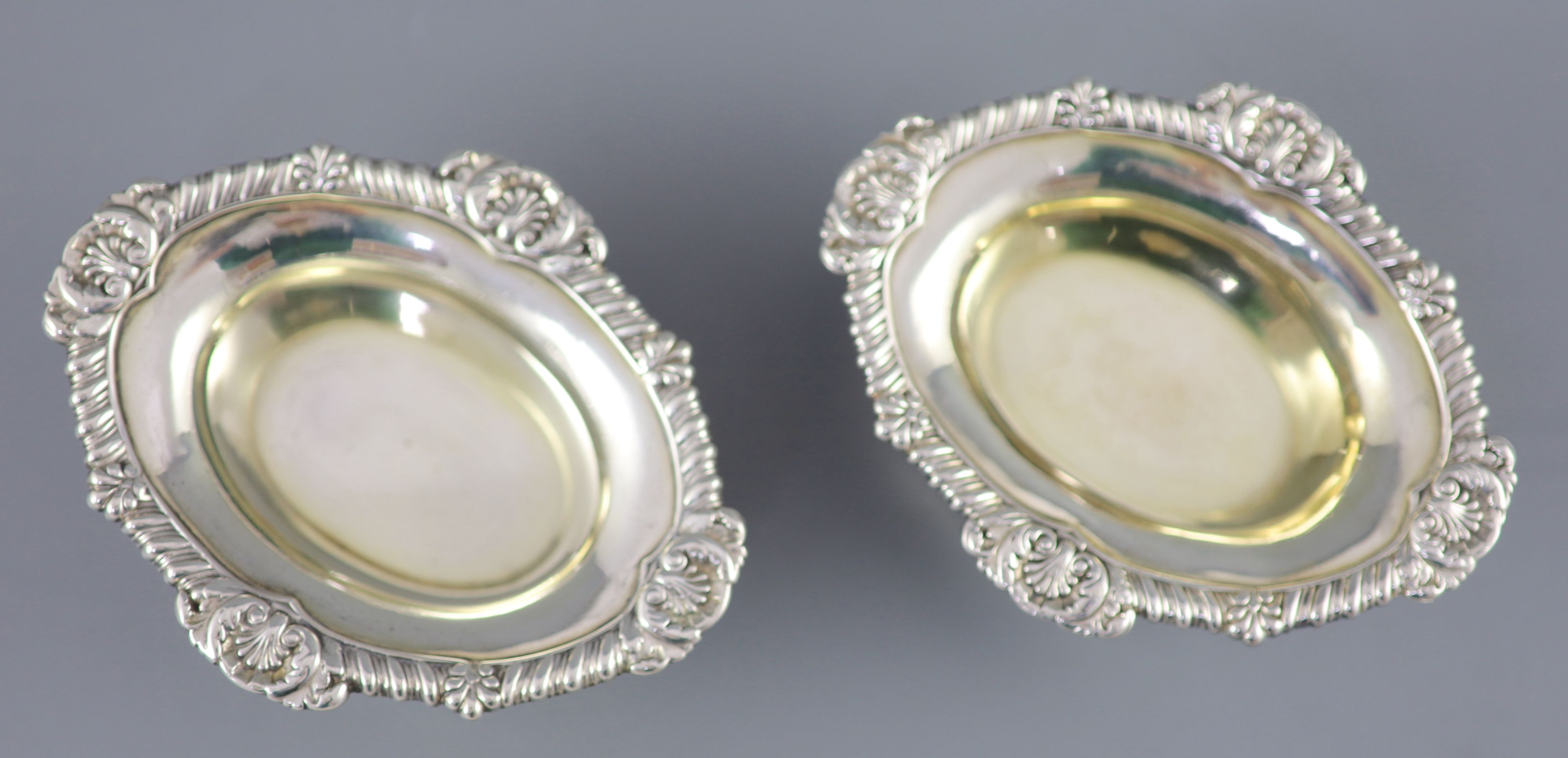 A pair of George III cast silver oval table salts by Paul Storr,